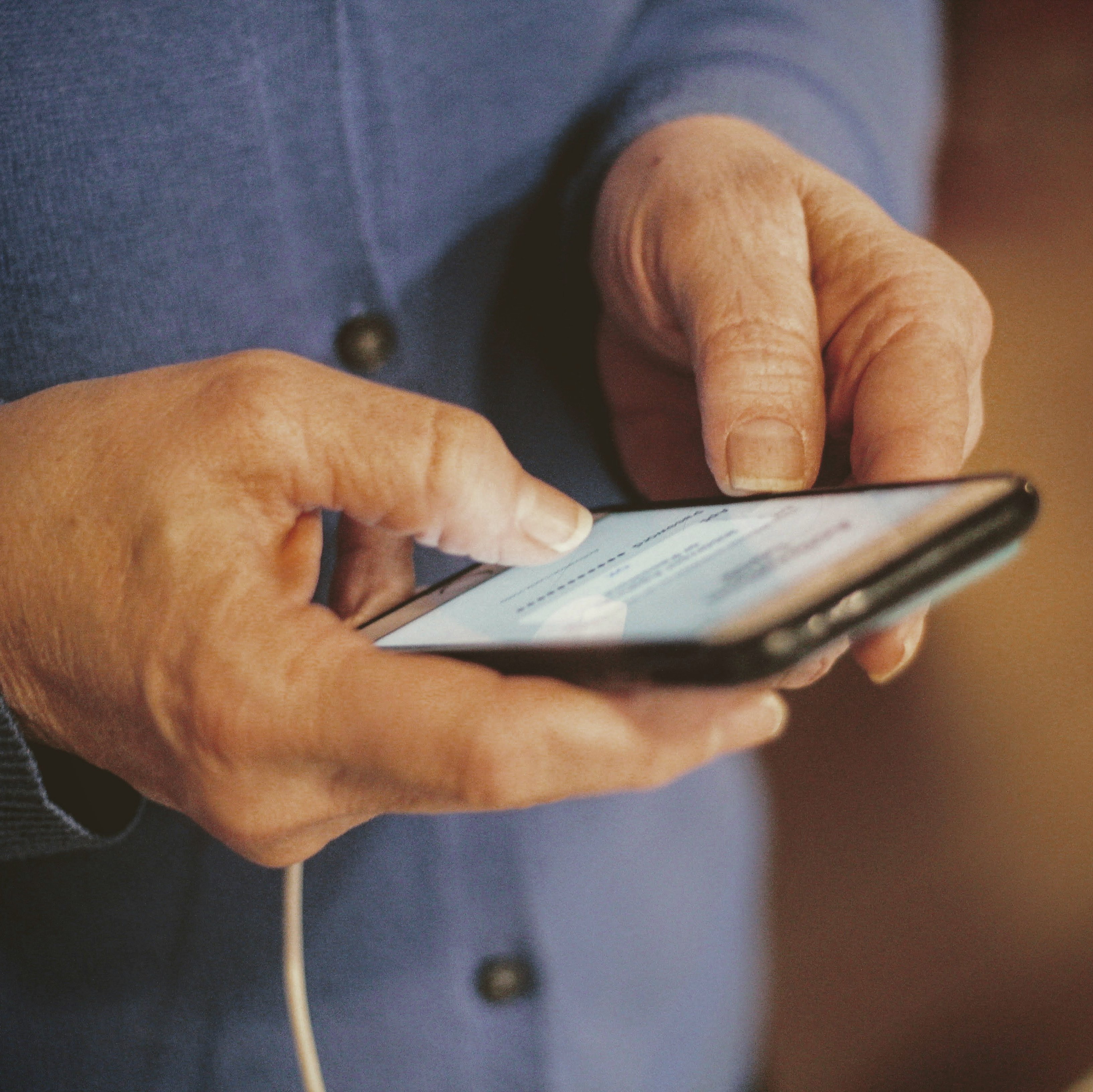 Ein älter Mann bedient ein Smartphone